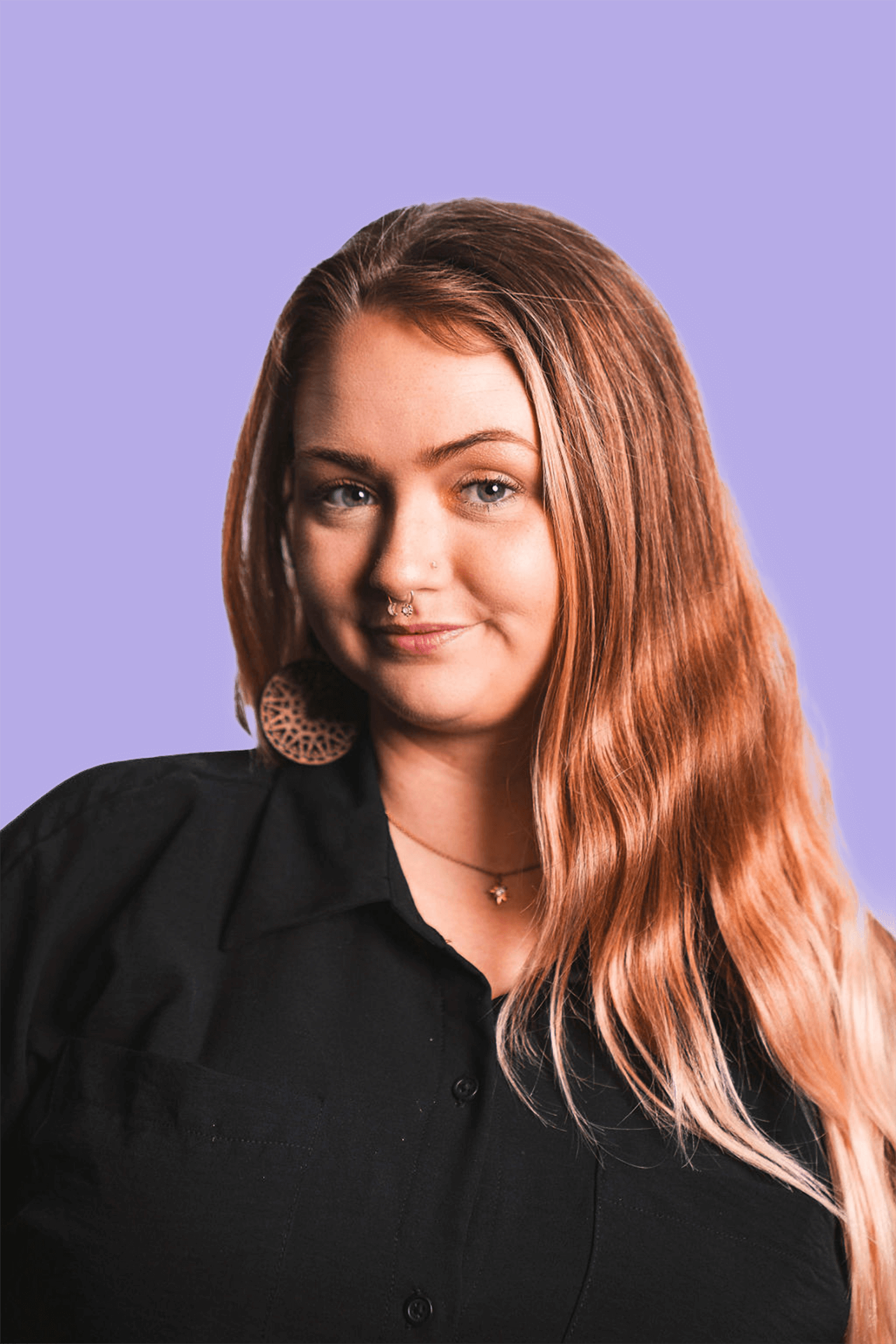 A photo of a blonde woman dressed in black with a purple background.
